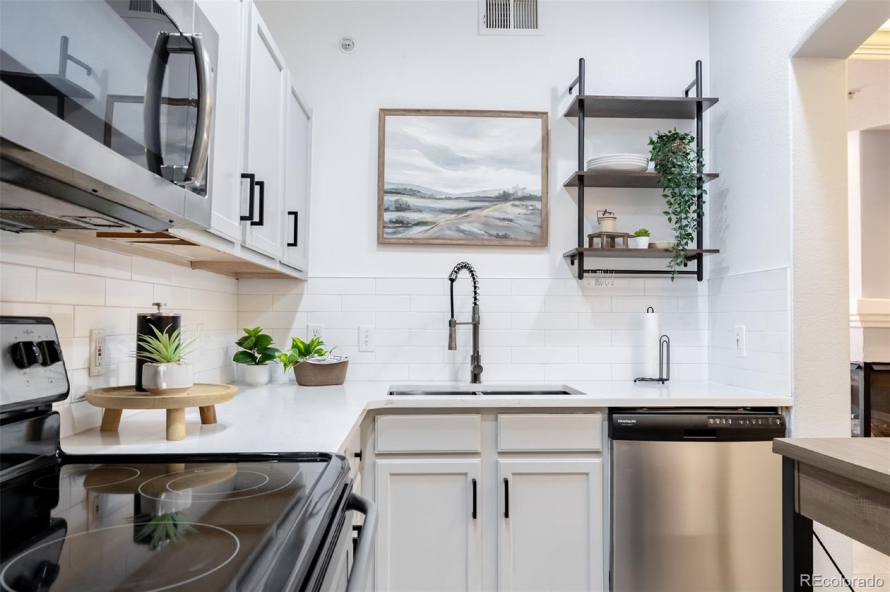 South Washington Street kitchen with warm wood shelving, greenery, and clear counters